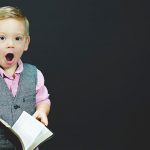 surprised little boy with book